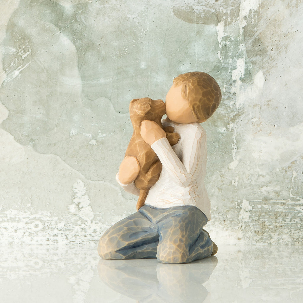 Willow Tree Kindness (boy), 3”h hand-painted resin figure of kneeling boy in neutral clothes, holding golden dog in arms, in front of gray painting
