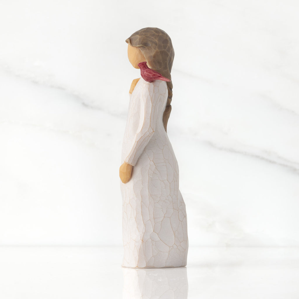Left side of standing figure in cream dress with cardinal red bird perched on shoulder