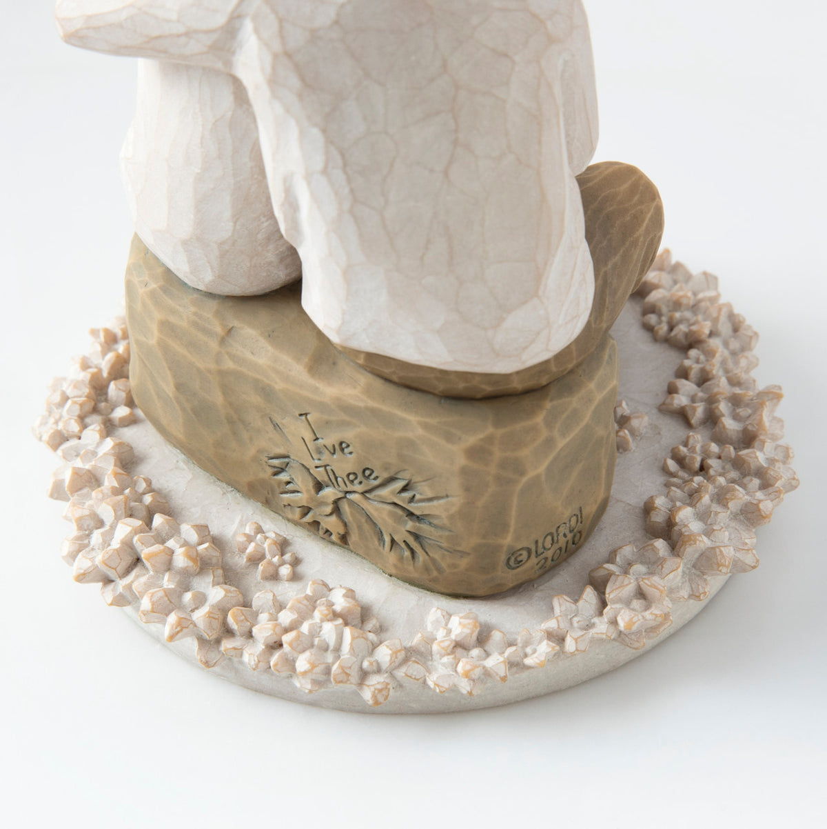 Close view of round white plaque with golden rock on top