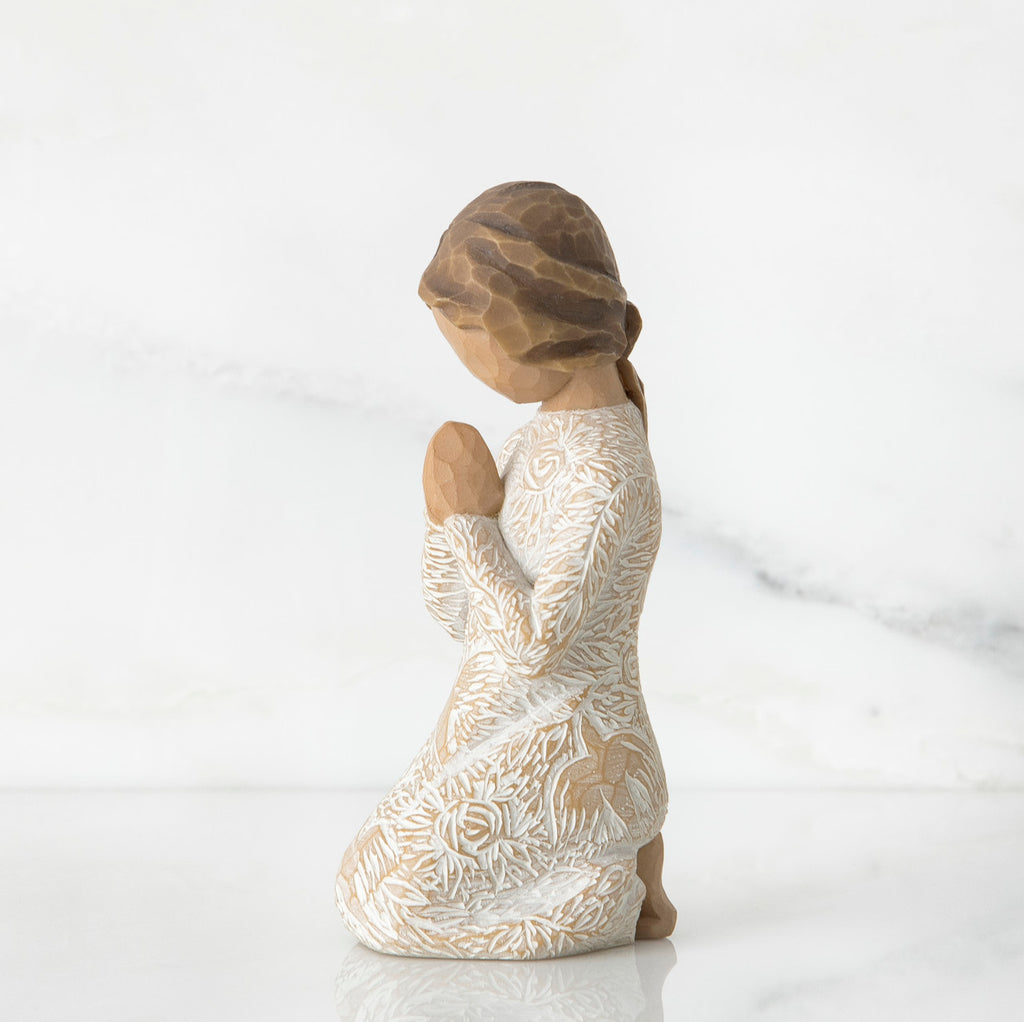 Small brunette girl figurine in white dress kneeling with hands folded - side view