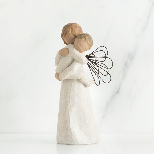 Angel figurine with black wire wings  in white holding baby in her arms