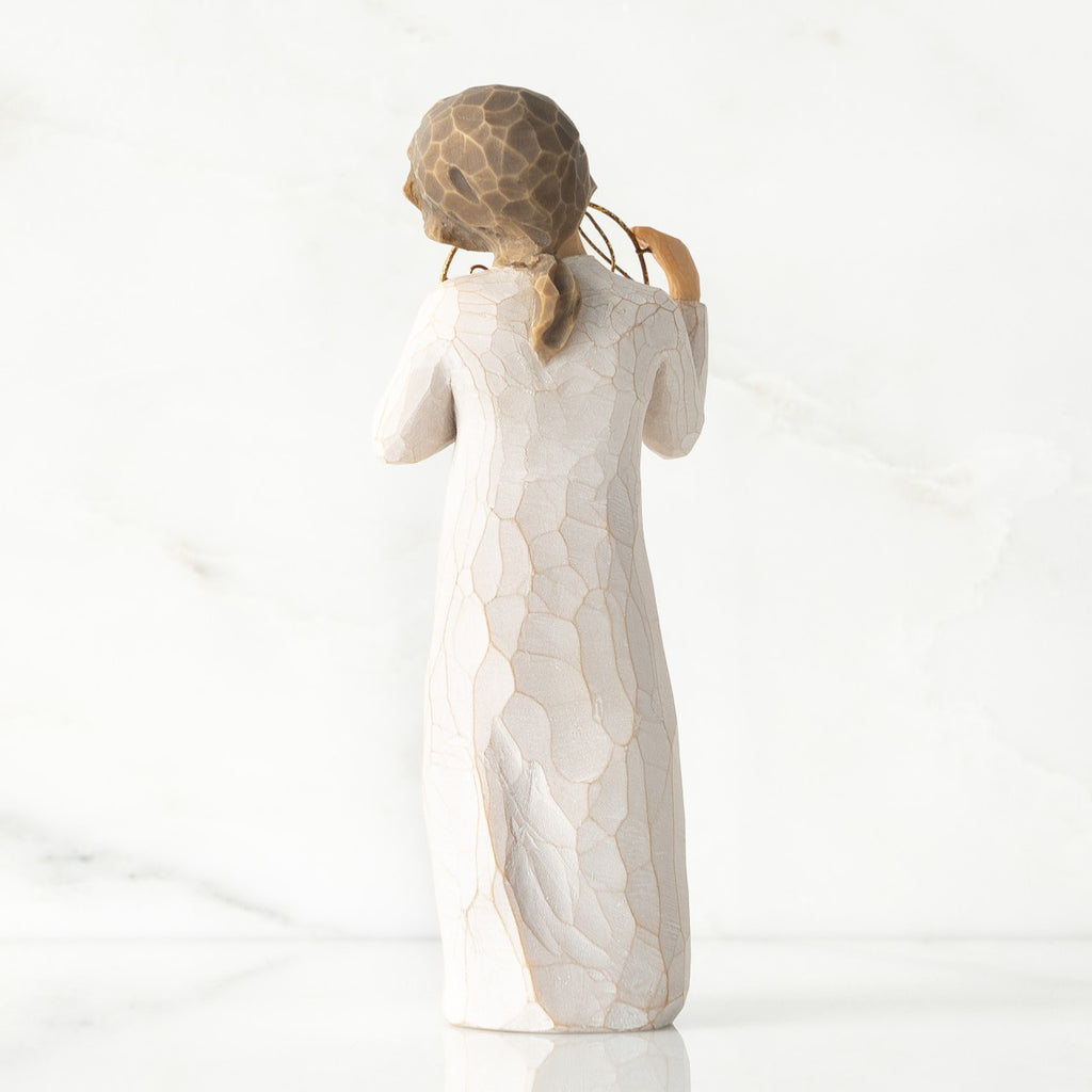 Back view, standing female figure in cream dress, holding gold wire circle in which is written 'love you'