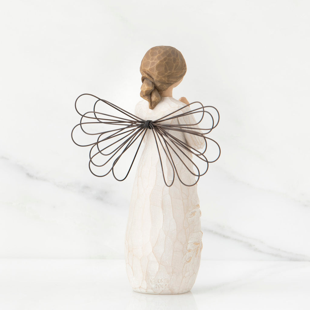 Back view of brunette girl figurine in white dress with brown wire wings standing up
