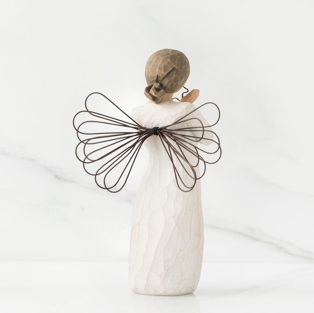Back view of angel figurine in white dress with brown wire wings