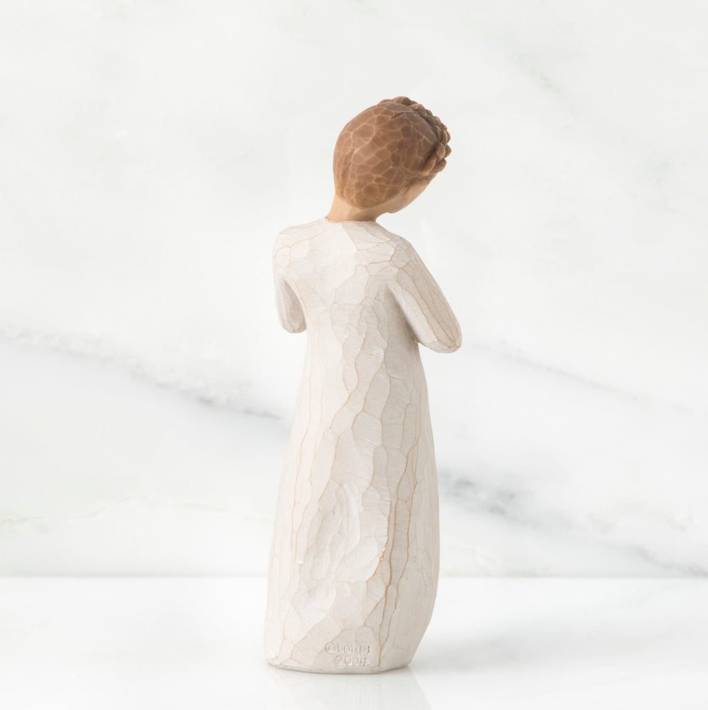 Back view of brown hair girl figurine standing in white dress