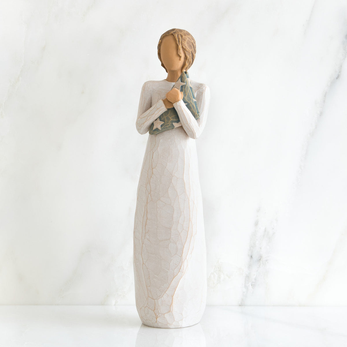 Faceless woman figurine standing facing forward wearing white dress holding star print napkin