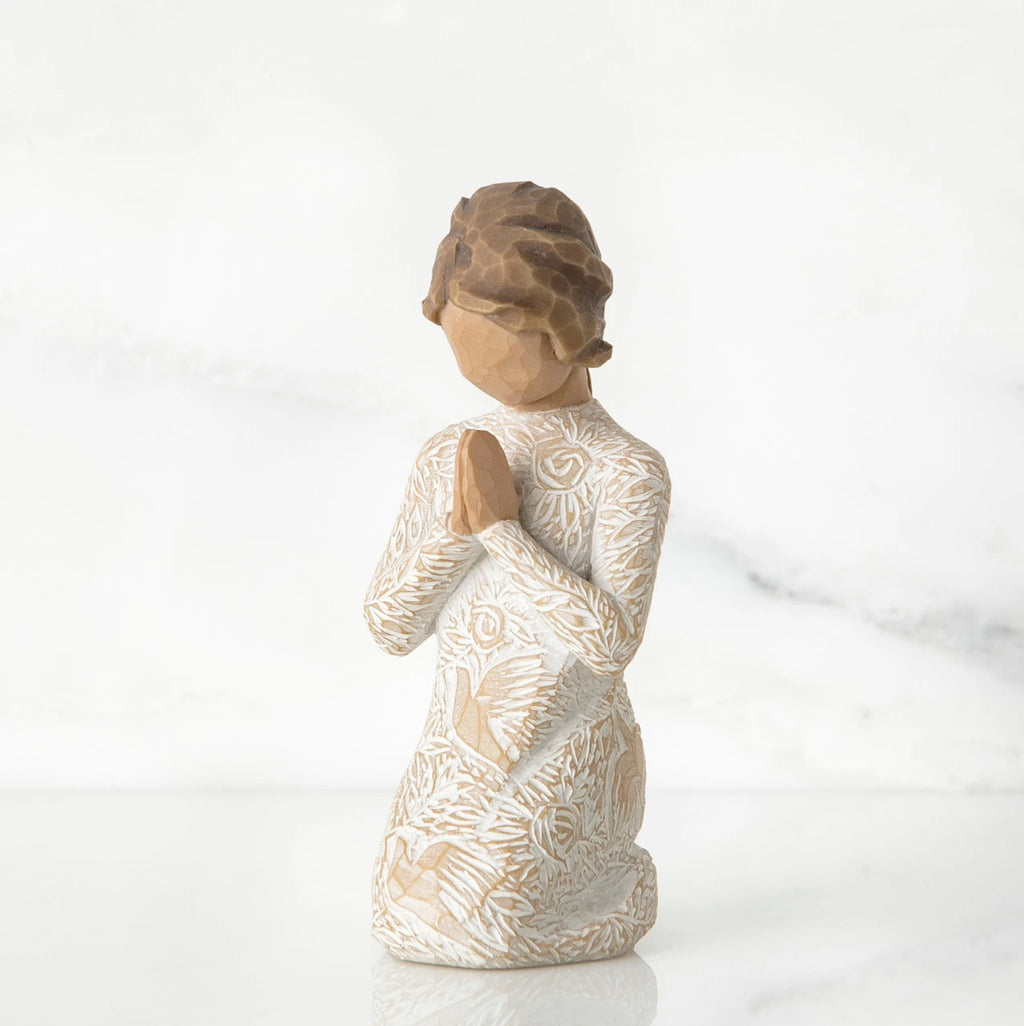 Small faceless girl figurine wearing white/tan bird design dress, kneeling and praying
