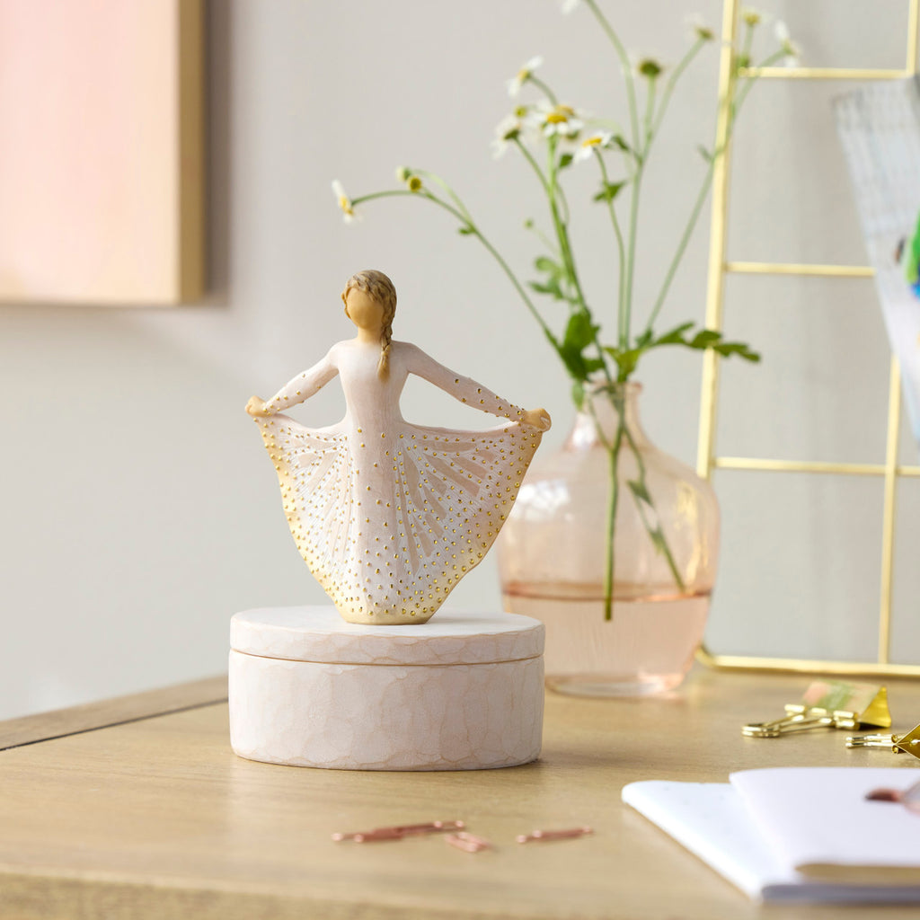 Willow Tree Butterfly Keepsake Box, 6.5"h x 4.5"h hand-painted oval resin box, 4.75”h figure holding cream skirt with carvings of monarch butterfly affixed to lid, closed on desk